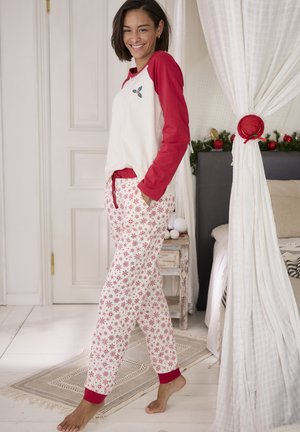 Rot-weißer Schlafanzug mit einem Top mit geschwunghem Saum, das rote Ärmel und ein besticktes Design aufweist. Die Hose hat ein Schneeflockenmuster und rote Bündchen.