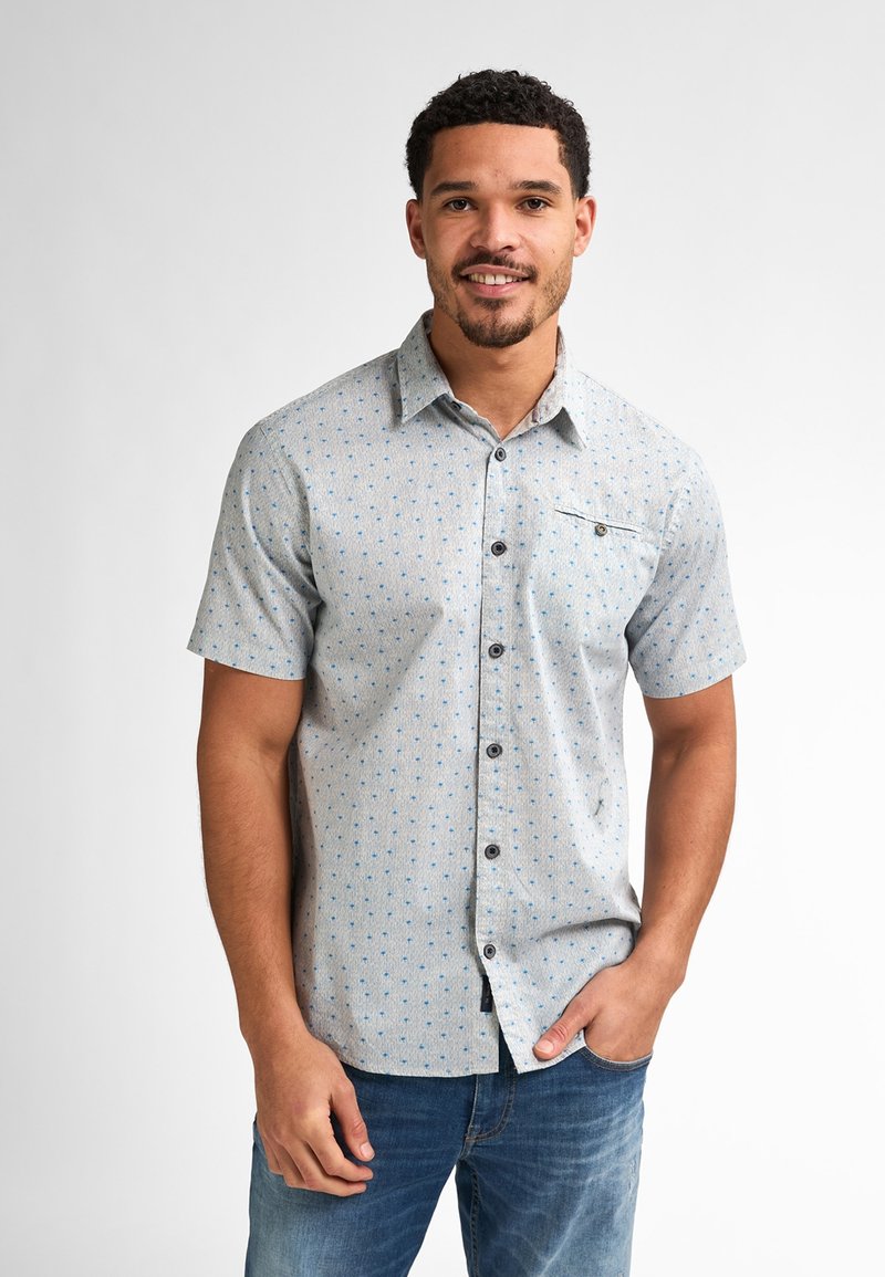 Camicia a maniche corte con bottoni in tessuto grigio chiaro, con un motivo geometrico blu, dotata di taschino sul petto e bottoni scuri.
