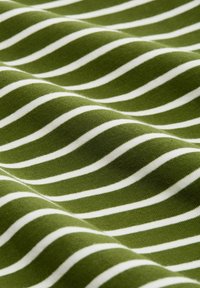 Katoenen stof met een golvend patroon, met afwisselend groene en witte strepen. Zachte textuur, met zichtbare plooien en rimpelingen.