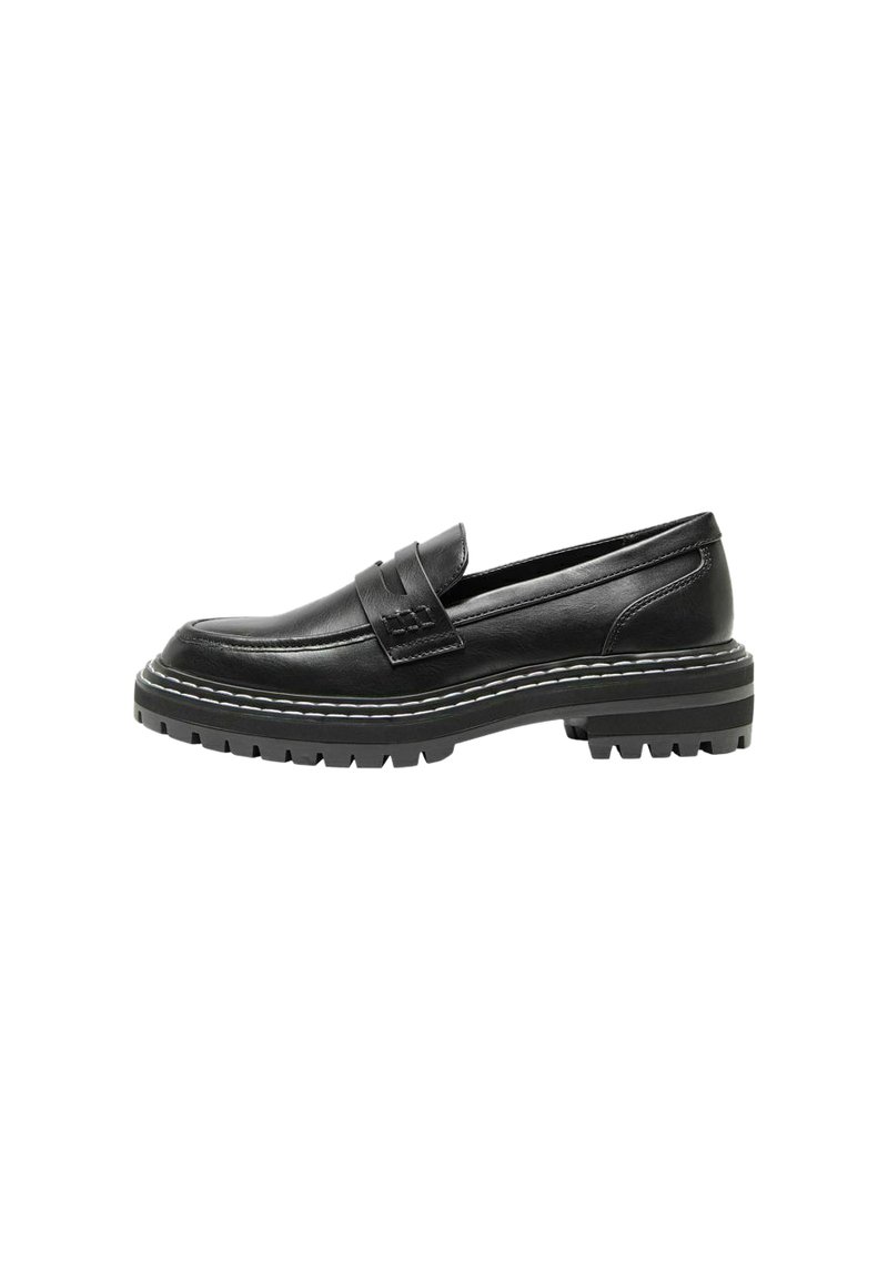 Mocasín de cuero negro con suela plana y resistente. Cuenta con una correa a través del empeine y costuras en blanco en los laterales.