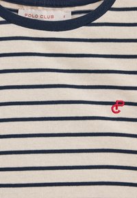 Randig t-shirt i beige och marinblå, med rund halsringning och liten röd broderad logotyp på bröstet. Mjuk, strukturerad tyg.