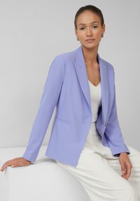 Lavendel blazer met een enkele knop, getailleerde pasvorm en met notched lapels. Draag het over een witte top, gecombineerd met lichte broek.