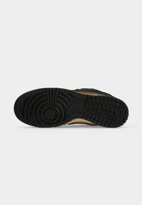 Σόλα αθλητικού παπουτσιού Nike με κυκλικά και ορθογώνια σχέδια πέλματος από μαύρο καουτσούκ, εμφανίζεται σε απλό ανοιχτό γκρι φόντο.