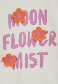 Purpuriniai užrašai „MOON FLOWER MIST“ ant balto fono, šalia trys oranžinės nertos gėlės su purpuriniais centrais.