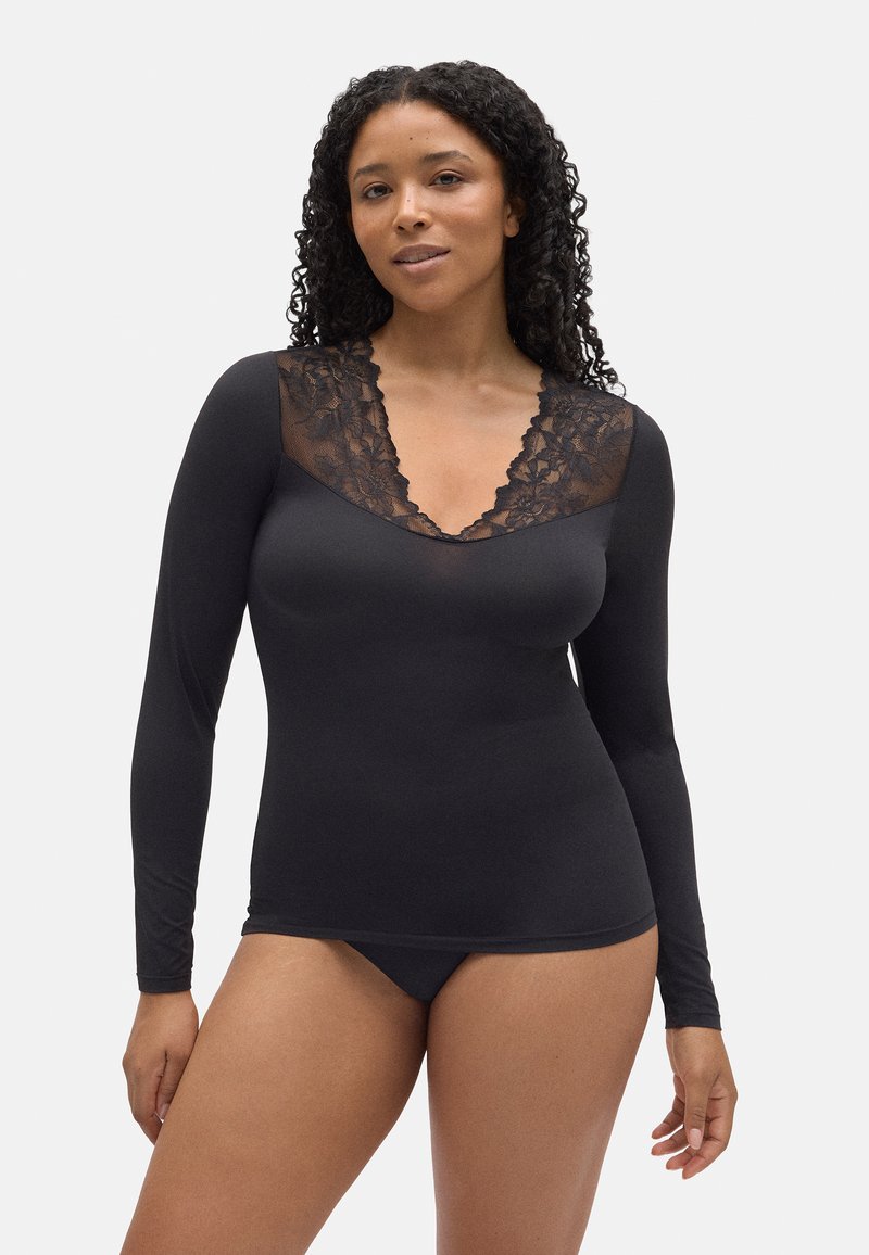 Camisa negra de manga larga con un diseño de escote en V de encaje negro transparente. Tejido suave con una forma ajustada, combinada con un pantalón a juego.