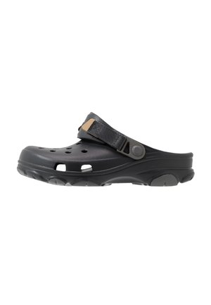 Sabot noir à enfiler avec trous de ventilation, bride arrière réglable et semelle texturée conçu pour un usage décontracté.