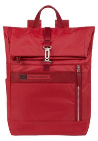 Zaino rosso in nylon con design a rotolo, hardware argentato, tasca frontale con zip e tasca laterale in rete. Presenta spallacci regolabili e logo.