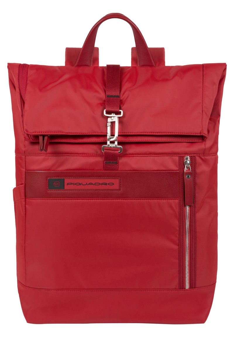 Zaino rosso in nylon con design a rotolo, hardware argentato, tasca frontale con zip e tasca laterale in rete. Presenta spallacci regolabili e logo.