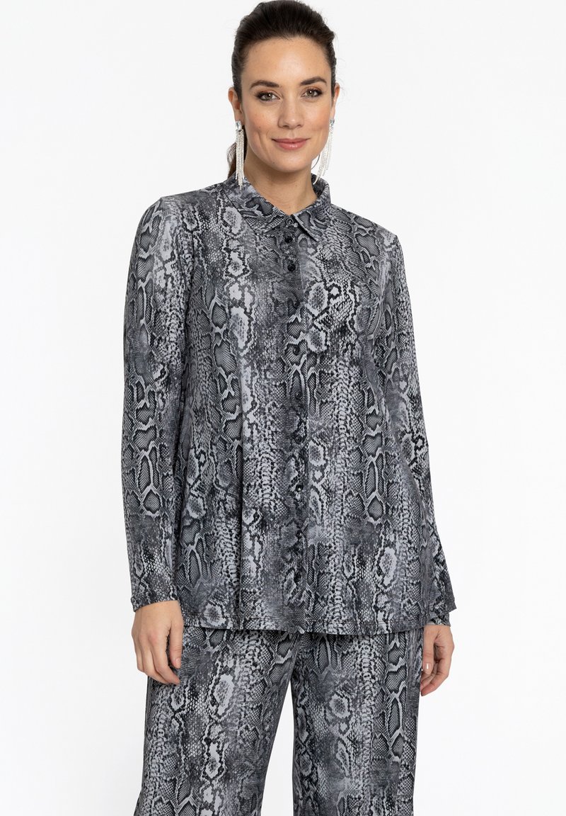 Blouse à imprimé serpent noir et gris avec un col, dotée de boutons sur le devant et de manches longues. Tissu lisse avec une coupe ajustée.