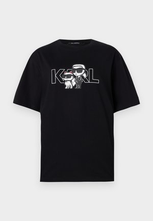 Must musta t-särk, millel on graafiline trükk kahest karikatuurikujudest prillidega, koos tekstiga "KARL" paksude tähtedega.