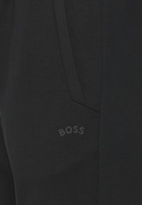 Svarta joggers med en mjuk textur, med en tonad "BOSS"-logotyp och en kontrasterande fickdesign för ökad detalj.