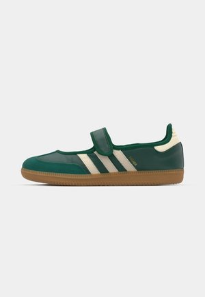 La sneaker verde presenta un materiale morbido e lucido, strisce bianche, una fascia in velcro e una suola in gomma testurizzata. Progettata per un uso casual.