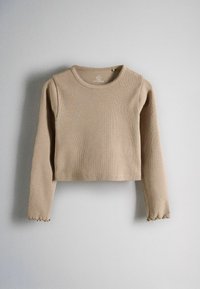 Beige ribbed long-sleeve cropped sweater with a round neckline and subtle ruffled cuffs hanging against a light gray background.