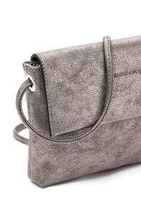 Borsa a tracolla in argento metallico con superficie texture, chiusura a pattina, manico circolare e tracolla regolabile. Gli accenti sono minimi.