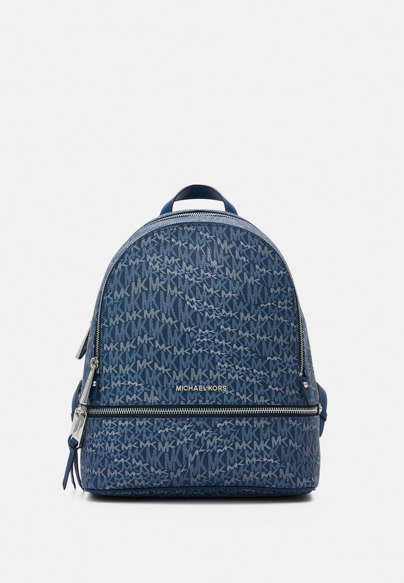Sac à dos bleu Michael Kors avec motif "MK" répété et poche frontale zippée, présenté sur un fond blanc uni.
