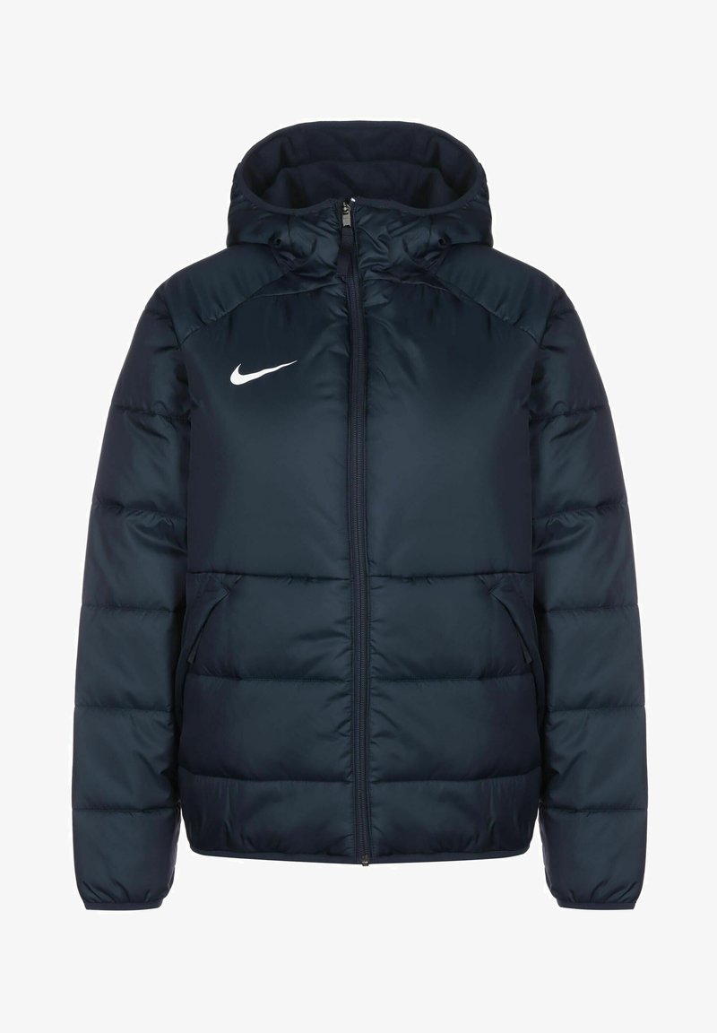 Giacca puffer blu navy con cappuccio, dotata di una zip completa e due tasche laterali. Include il logo bianco di Nike sul petto.