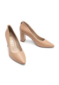 Beige nahka korkokengät, joissa on terävä kärki, keskikokoinen lohkokorko ja pieni vetoketj yksityiskohta nilkan takana. Sujuva pinta.