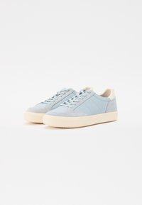 Light blue sneakers with suede and leather materials, round toe, lace-up front, cream rubber sole, and side panel accents.
