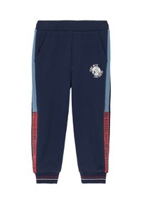 Marineblauwe joggingsbroek met een geribbelde tailleband, zijzakken, lichtblauwe panelen en rode accenten, voorzien van de tekst "Dino Kickers" en een logo.