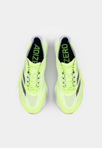 Lyse neongule løbesko med en mesh-overdel, med "ADIZERO" branding på tungen og siden, placeret mod en hvid baggrund.