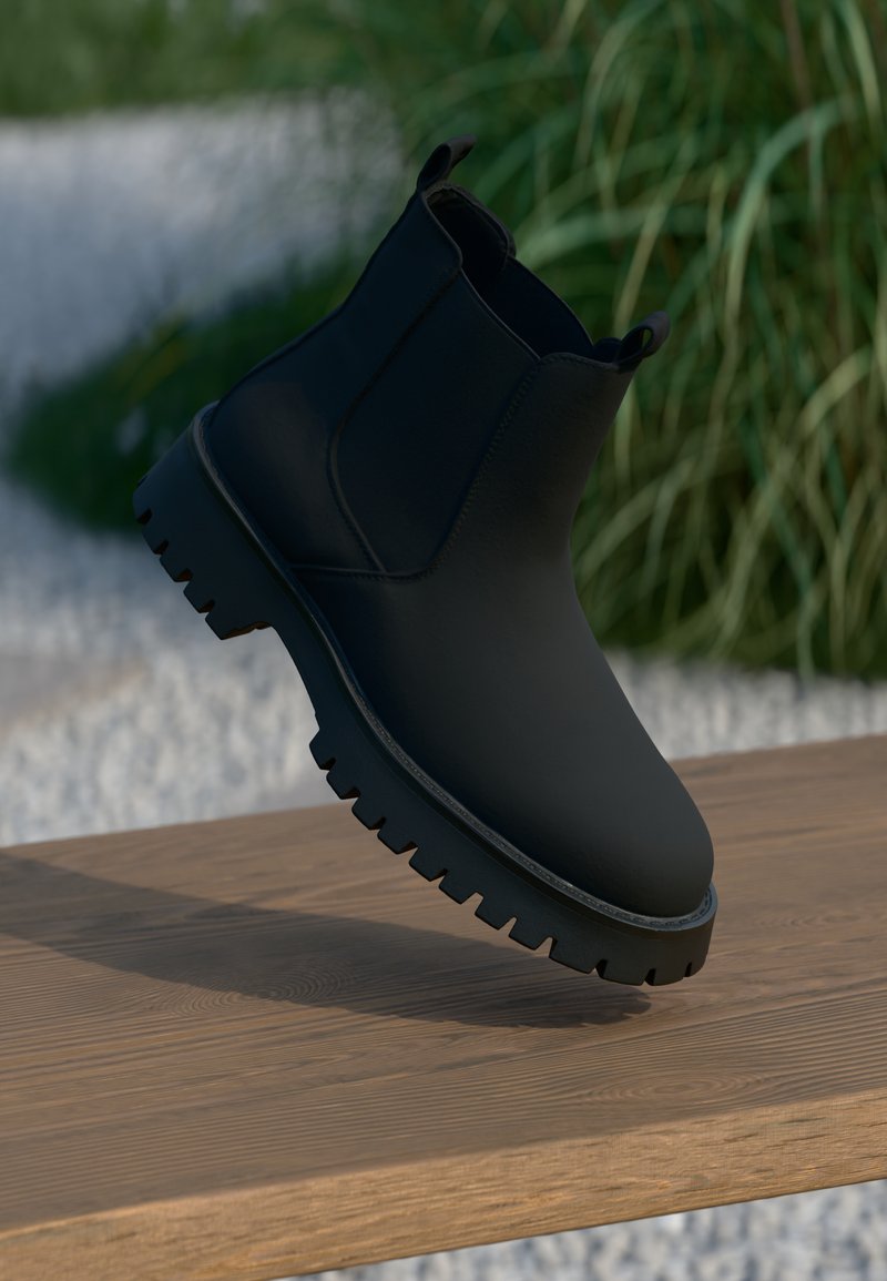 Sorte ankelstøvler med en glatt finish, elastiske sidepaneler og en tykk, robust s�åle. Plassert mot en naturlig bakgrunn på en tresurface.