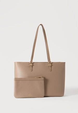 Sac cabas en cuir beige avec double anses et pochette assortie à fermeture éclair placée devant sur un fond blanc.