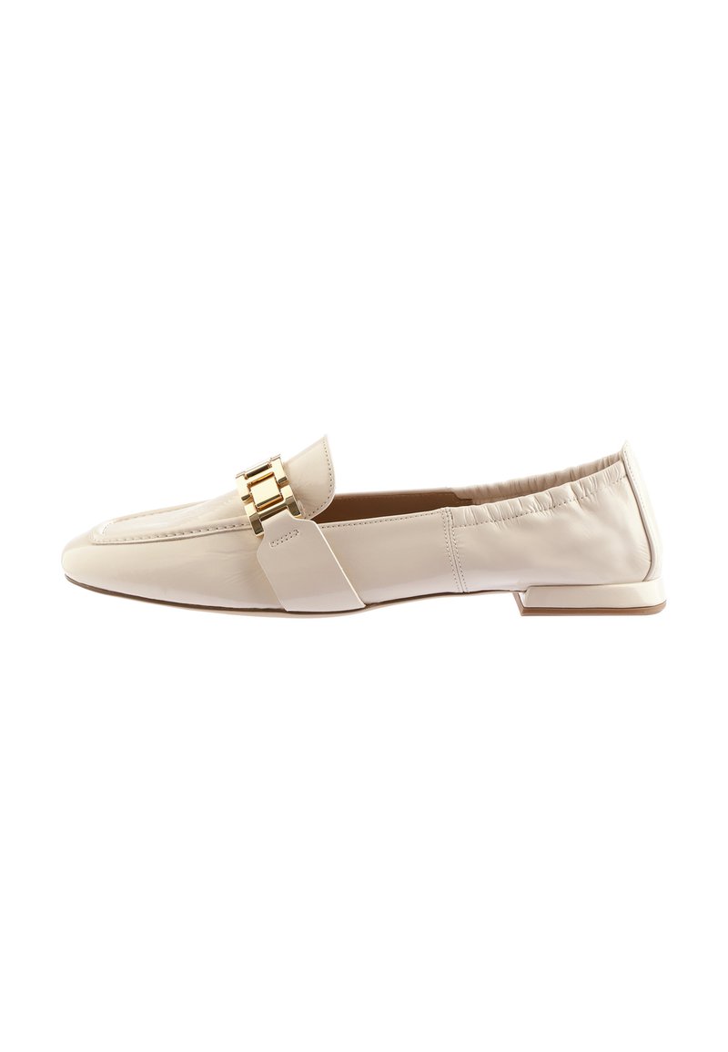 Mocassins en cuir beige avec une semelle plate, dotés d'un accent en métal doré et de détails froncés au niveau du talon pour un ajustement sécurisé.
