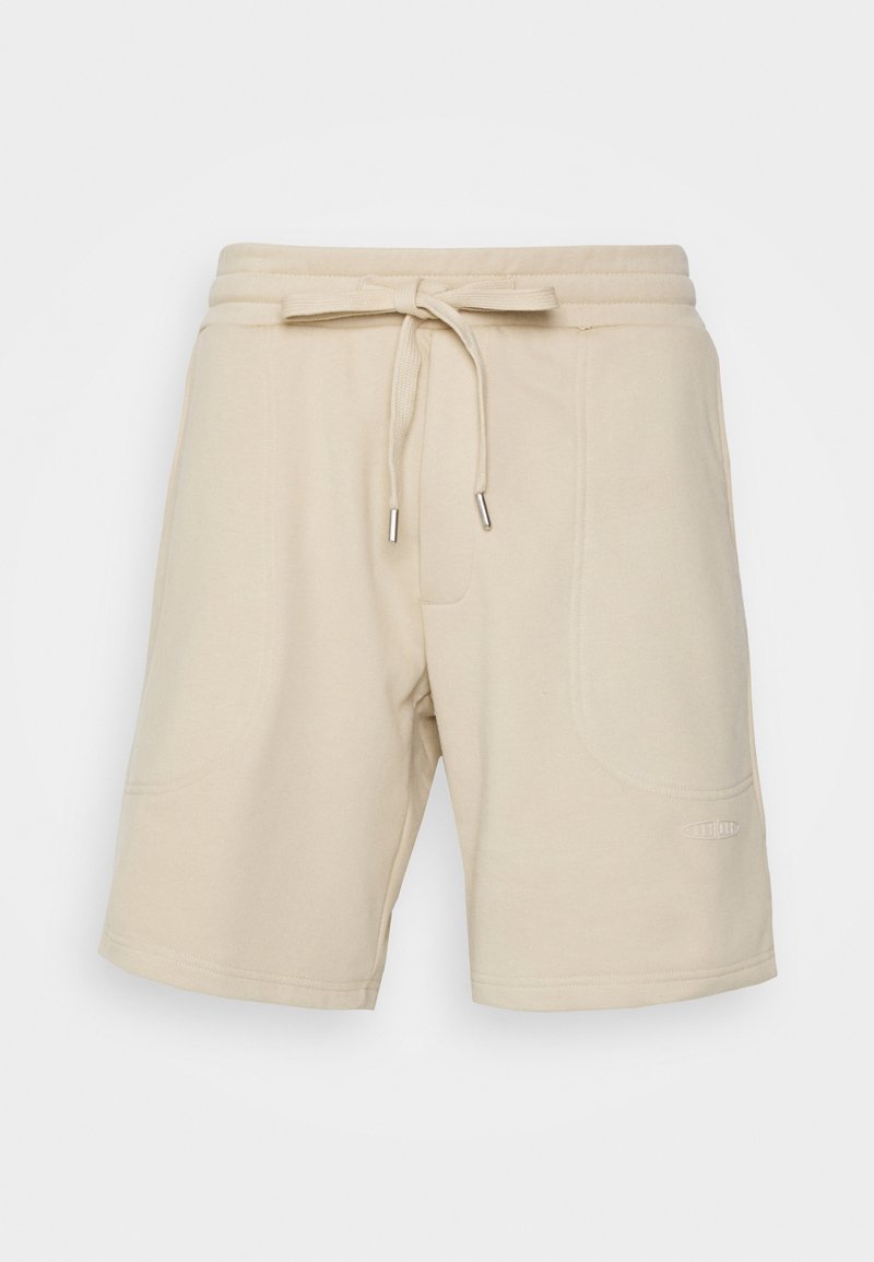 Shorts en coton beige avec une taille élastique et un cordon de serrage. Comprend deux poches latérales et un branding discret sur l'ourlet. Texture lisse.
