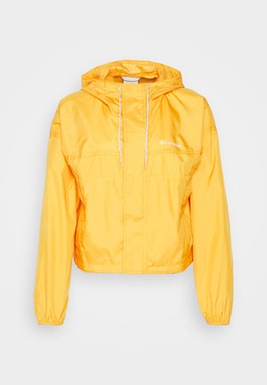 Żółta lekka kurtka z kapturem, zapinana z przodu na zamek, z elastycznymi mankietami oraz logo Columbia na lewej piersi.