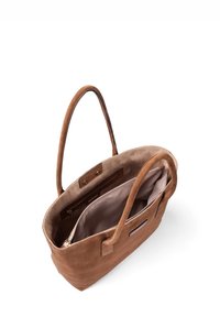 Sac fourre-tout en daim marron avec deux longues poignées, un dessus ouvert et un intérieur beige. Comprend une poche intérieure zippée et un design minimaliste.