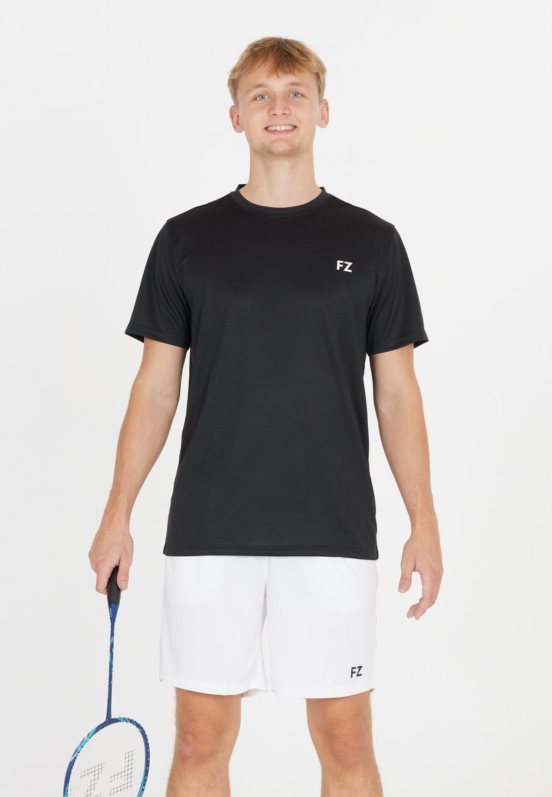 Svart tränings t-shirt med korta ärmar, med en liten vit "FZ" logotyp på vänster bröst. Bärs med vita shorts och håller en badmintonracket.