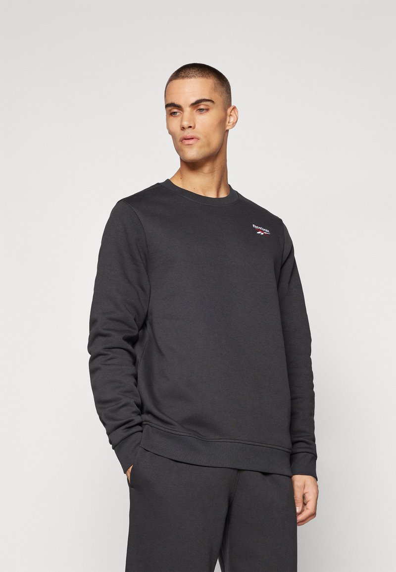 Sweatshirt pour homme gris foncé en coton doux, avec un col rond, des manches longues et un petit logo sur la poitrine gauche.