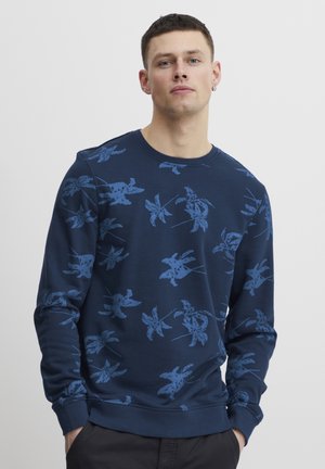 Sweatshirt bleu marine avec un motif floral texturé en bleu clair, col rond et manches à bords-côtes. Tissu doux avec une coupe décontractée.
