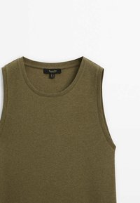 Débardeur côtelé vert olive avec larges bretelles et encolure arrondie. Étiquette attachée au col indiquant la taille et la marque.