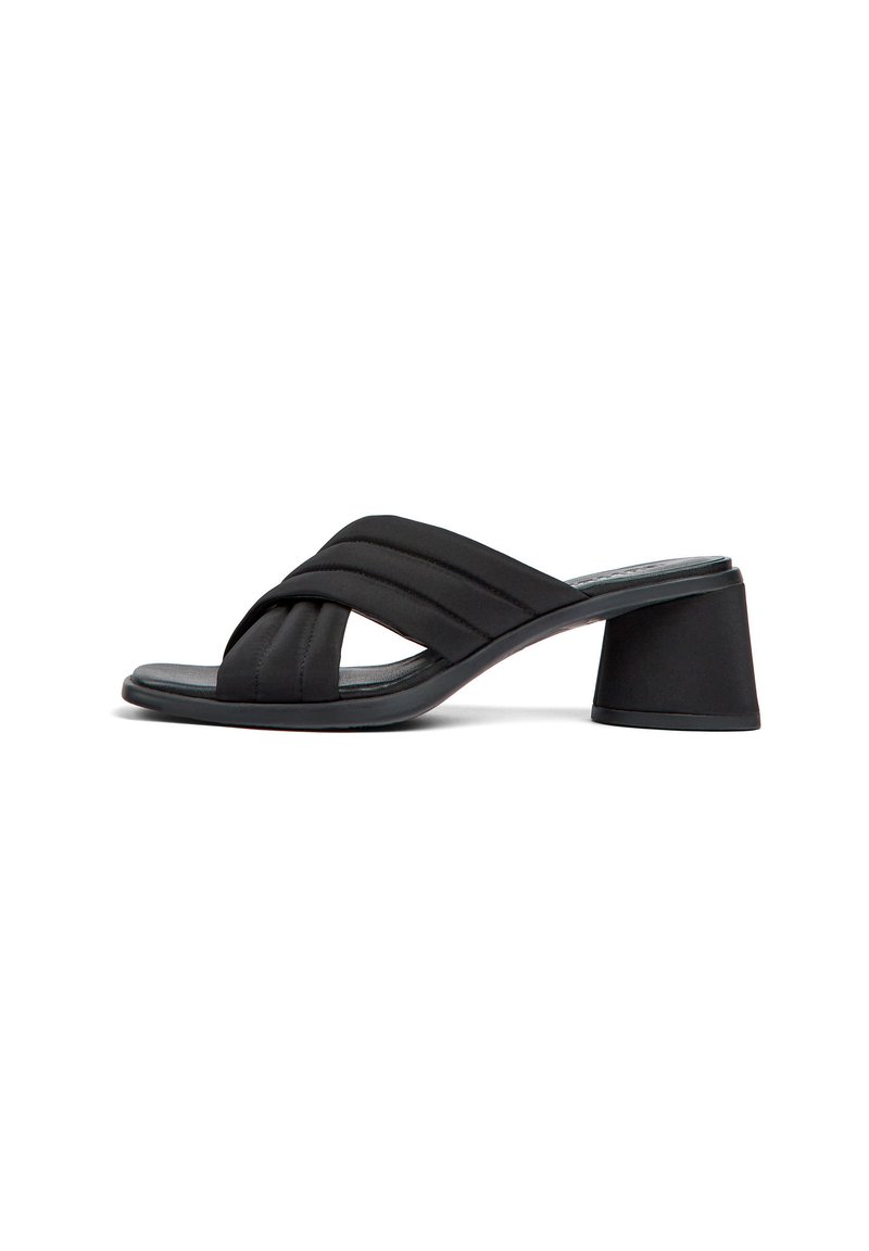 Mules noires à talons avec un design de bride croisée rembourrée. Dessus en tissu doux et talon large et rond. Semelle plate pour un port facile.
