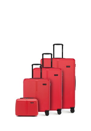 Quatre valises rigides rouges de tailles variées avec des poignées extensibles noires et des roues, disposées en ordre croissant de l'avant vers l'arrière.