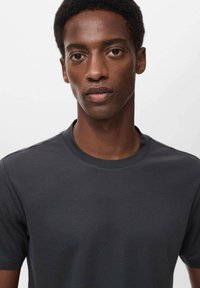 Donkergrijze crewneck t-shirt van gladde stof. Getailleerd ontwerp, korte mouwen, minimalistische stijl zonder zichtbare patronen of accenten.