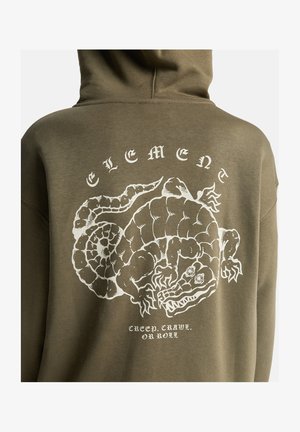 Bag på olivengrøn hoodie med hvid grafik af en stiliseret alligator og teksten "ELEMENT" samt "Creep. Crawl. Or Roll."