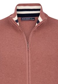 Sudadera rustica con cremallera hecha de tela texturizada, con un cuello acanalado que presenta franjas en azul marino y blanco. Etiqueta de la marca visible en el interior.