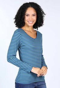 Langärmliges, V-Ausschnitt-Shirt aus geripptem Stoff mit abwechselnden grünen und blauen horizontalen Streifen. Weicher Stoff mit figurschmeichelnder Silhouette.