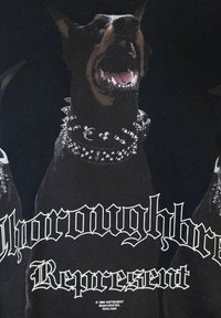 Tessuto nero con un Doberman che indossa un collare borchiato, mostrando denti affilati. Il testo recita "Rappresentanza di Razza Pura" in grassetto bianco.