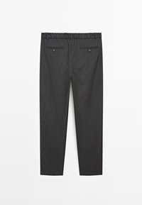 Šedé kalhoty na míru vyrobené z látky s jemnou texturou, s pružným pasem, dvěma zadními kapsami a rovnými nohavicemi.