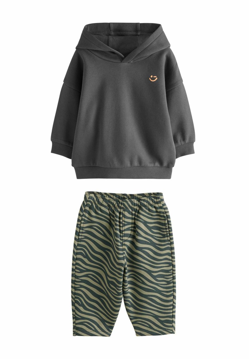 Dark gray hoodie with a V-neck and small orange logo, paired with green zebra-striped shorts featuring an elastic waistband.