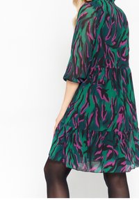 Zelené a černé šaty s abstraktním fialovým vzorem, krátké nabírané rukávy, nabíraná sukně, lehký materiál a volný střih.
