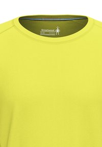 Gul kortærmet skjorte med rund halsudskæring, fremstillet af åndbart materiale. Har et minimalistisk design med flade sømme og brandlogo indeni.