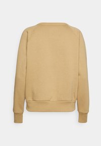 Beżowy sweter z okrągłym dekoltem i ściągaczami. Charakteryzuje się gładką teksturą oraz luźnym krojem z bezszwowym wykończeniem ramion.