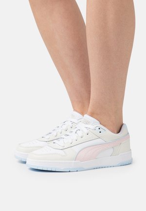 Sneakers bianchi in pelle con dettagli rosa chiaro, punta perforata e suola in gomma blu. I lacci e il marchio sulla linguetta sono visibili.
