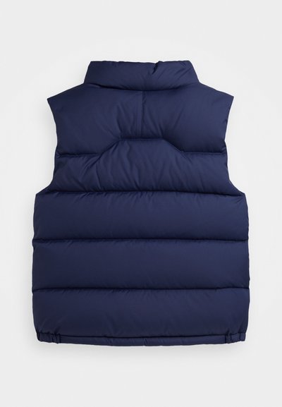 Svetlo modra podložena brezrokavnika z visokim ovratnikom, horizontalno prešitimi sekcijami in elastičnim robom. Narejen iz gladkega, lahkega materiala.