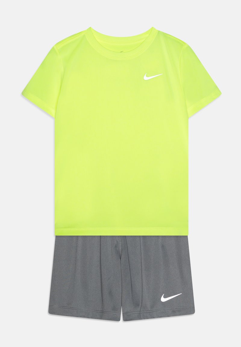 Nike aktiivivarustus, joka sisältää kirkkaan keltaisen lyhythihaisen paidan ja harmaat shortsit, joissa molemmissa on valkoinen logosauma. Sujuva, hengittävä kangas.