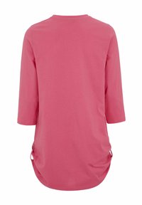 Pitkähihanen vaaleanpunainen jersey-paita pyöreällä kaula-aukolla, jossa on sivusiteet ja kaareva helma lisäämään yksityiskohtia ja liikkumisen helppoutta.